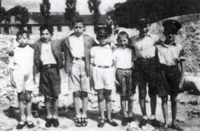 שבעה ילדים בגטו פיוטרקוב טריבונלסקי, בהם יצחק (איציק) רייכנבאום (בעלה של המוסרת, בלה רייכנבאום) עומד שני משמאל.