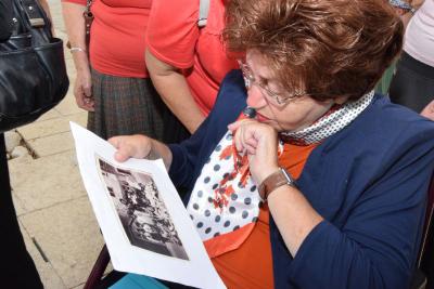 Survivor Tova Silverstein looks at a photo of herself, her sister Matylda and other children at the postwar children&#039;s home in Marquain, Belgium. Her father, Hersch Lowenbraun, stands in the background - he was one of the children&#039;s teachers at the home