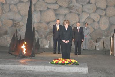 German Chancellor Dr. Angela Merkel lays a wreath in the Hall of Remembrance. To the Chancellor&#039;s left is Prime Minister Ehud Olmert and to her right is the Chairman of the Yad Vashem Directorate Avner Shalev