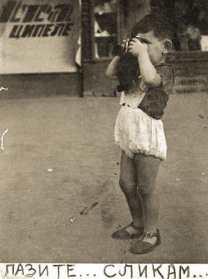 Werbefoto mit Gavra Mandil für das Fotostudio seines Vaters in Novi Sad. Der serbische Text unter dem Foto bedeutet: „Achtung – Ich mache Fotos“, 1939 