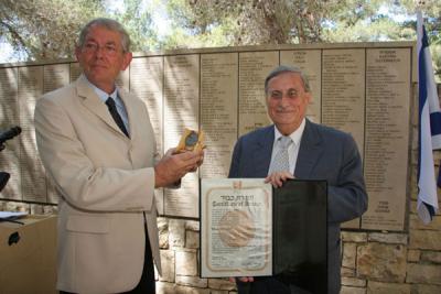 Henk Brink accepts the certificate and medal of honor of Righteous Among the Nations on behalf of his late father Henk Drogt from the Chairman of the Commission for the Designation of the Righteous Among the Nations, Supreme Court Justice Yaacov Turkel