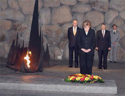 קנצלרית גרמניה, ד&quot;ר אנגלה מרקל, מניחה זר בטקס הזיכרון באהל יזכור. מאחור ניצבים ראש הממשלה אהוד אולמרט (משמאל) ויו&quot;ר הנהלת יד ושם אבנר שלו