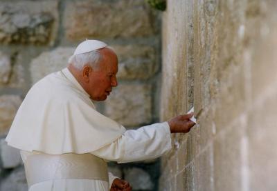 El Papa Juan Pablo II colocando la nota con su mensaje entre las piedras del Muro Occidental, 26 de marzo 2000