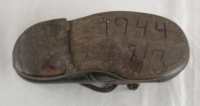 Zapato de párvula de Hinde Cohen en el cual aparece grabada la fecha de su deportación hacia la exterminación
