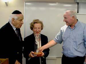 Ishai Amrami, Yad Vashem Director-General, presents the Weiszs with the six-branched candlabra, the symbol of Yad Vashem