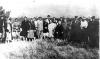 Holocaust survivors gather at a mass grave, Dubno, 1945