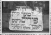 שלט עם ציטוט המיוחס להיטלר, "יהודים כבר לא יחגגו פורים", מחנה העקורים לנדסברג, 1946 בערך