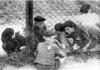 Женщина и дети по разные стороны забора в гетто Лодзь, Польша