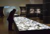 Sur une table illuminée, au centre de l'exposition, plus de 1500 photographies prises pendant la Seconde Guerre mondiale