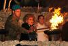 Hedy Hirsch, One of the six designated torchlighters lights a torch during the ceremony