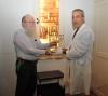 Yehuda Mansbach [left] receives the Hanukka menorah from Michael Tal, [right] an artifacts curator at Yad Vashem