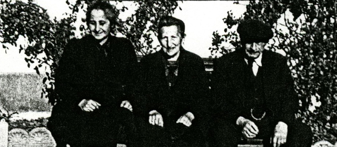 Bertha Weinschenk sitzt auf einer Bank zwischen zwei anderen Überlebenden. Lausanne, Februar 1945