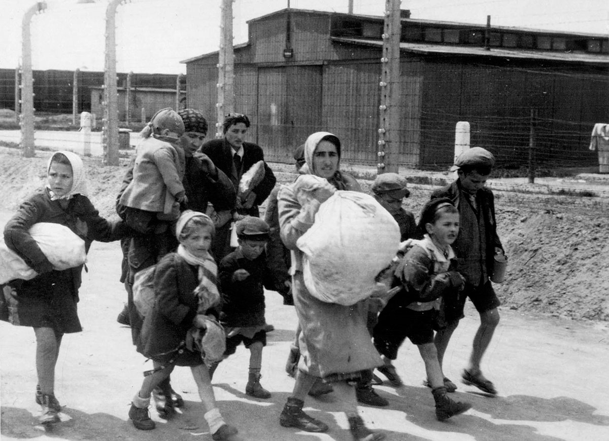 Jewish women and children forced to walk along the camp's barracks toward the gas chambers