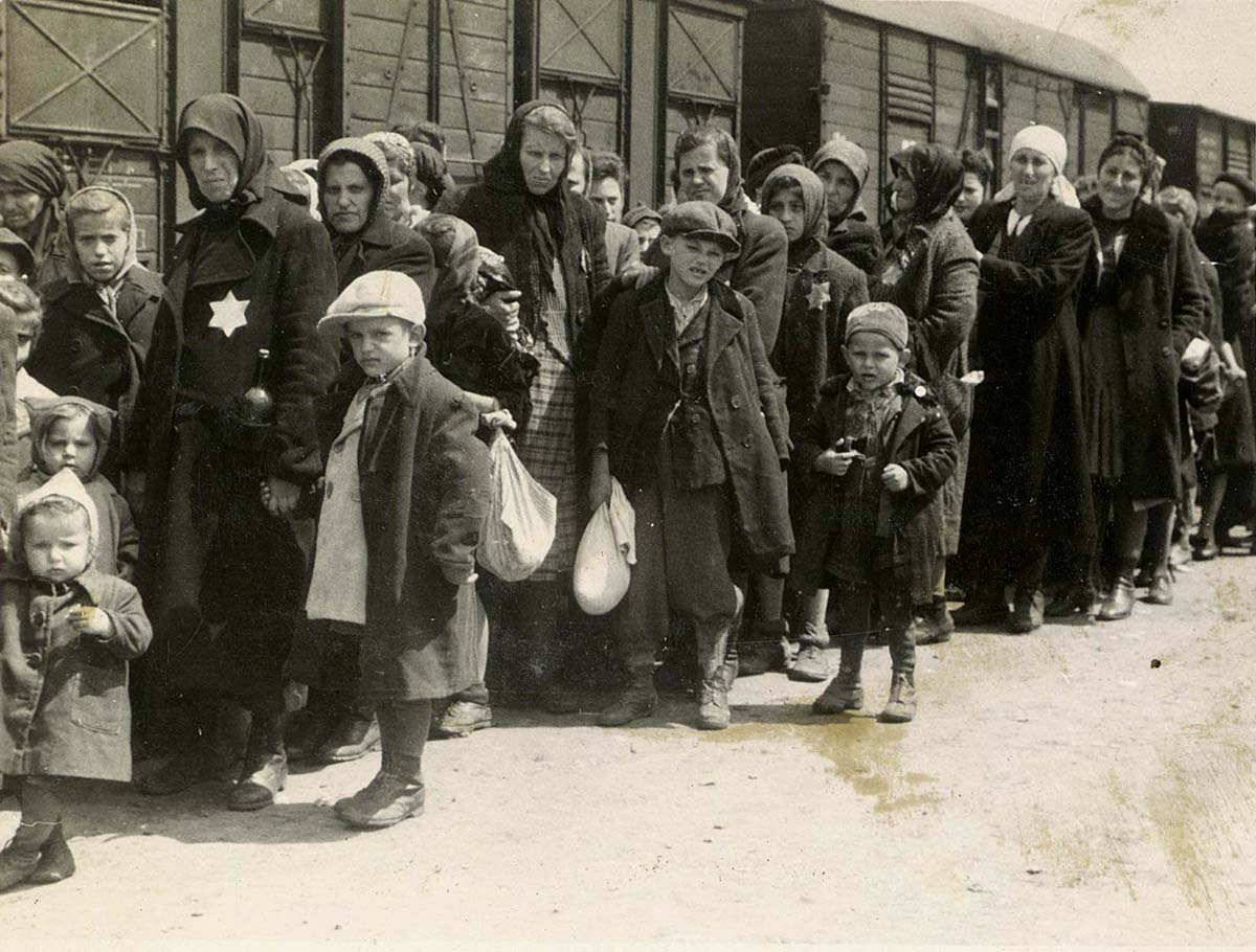 Mujeres y niños en la plataforma de llegada de Auschwitz conocida como la  "rampa". Los judíos eran sacados de los trenes de deportación a la rampa donde pasaban por un proceso de selección; algunos eran enviados de inmediato a su muerte y otros a trabajos forzados