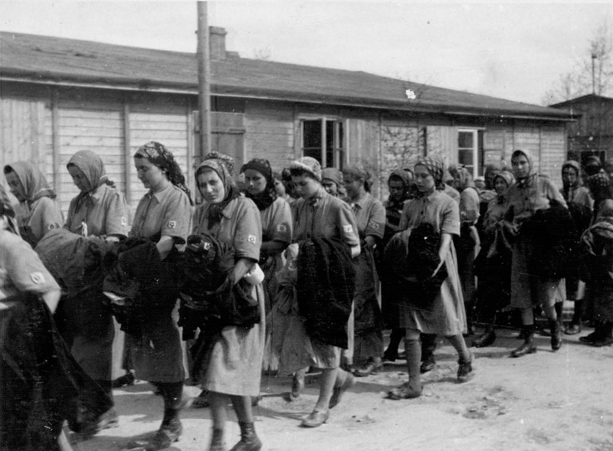 Weibliche Häftlinge nach der Registrierung auf dem Weg zu den Wohnbaracken 