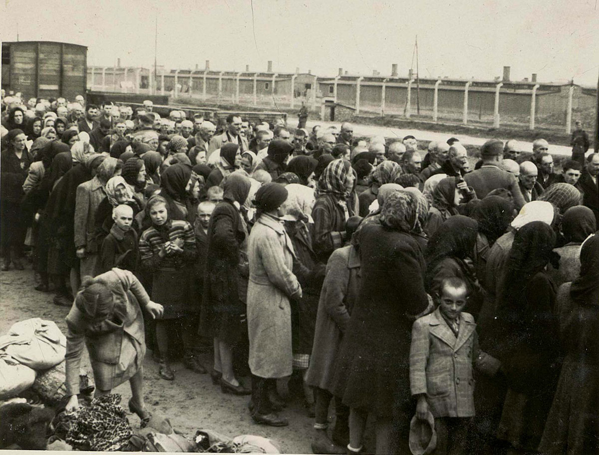 יהודים שהגיעו הרגע למחנה אך טרם עברו סלקציה. משמאל למטה נראים חלק מהחפצים שהיהודים הביאו עמם. החפצים נותרו על הרציף עד לאחר תום הסלקציה