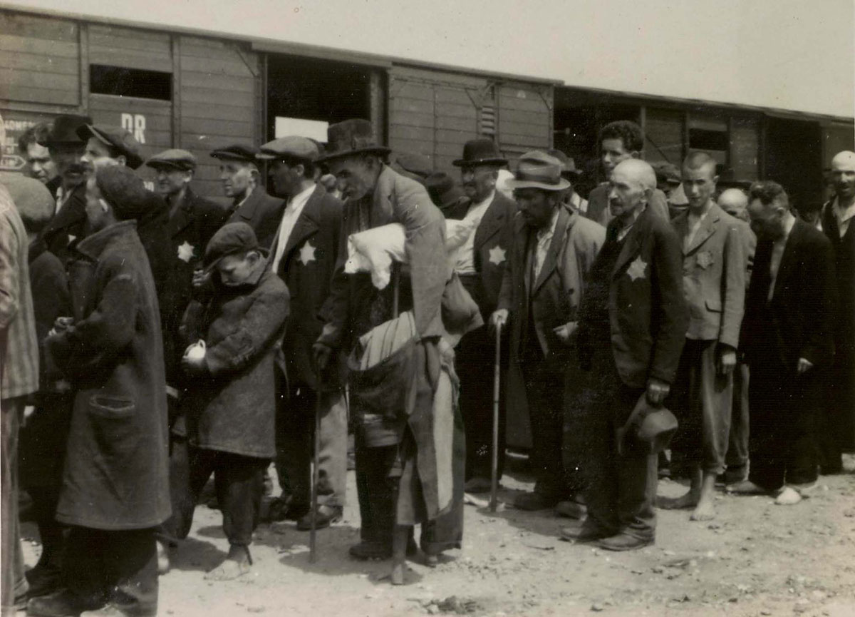 ילדים, מבוגרים וקשישים יהודים עומדים בשורה לפני תחילתה של הסלקציה