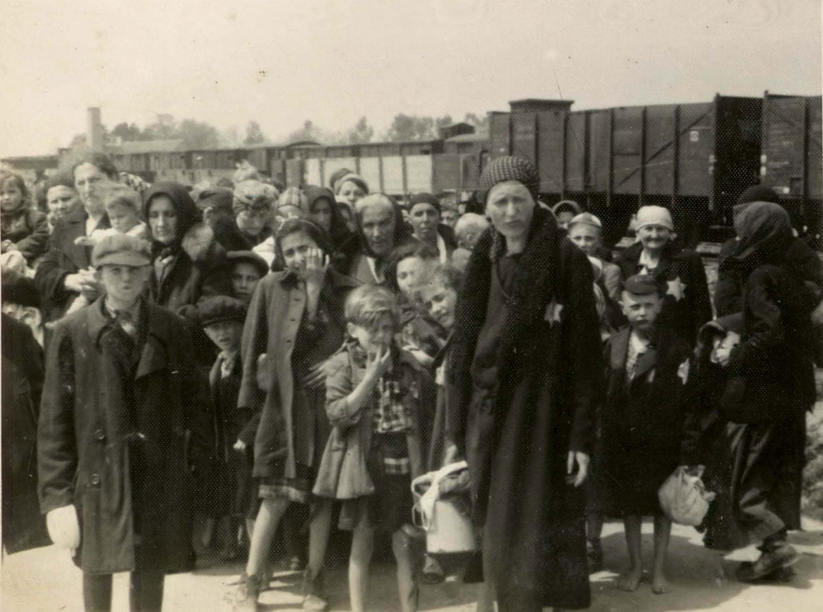 Женщины и дети на железнодорожной платформе Биркенау, известной как «рампа». Депортированные евреи проходили здесь селекцию: одних сразу же посылали на смерть, других отправляли на принудительные работы