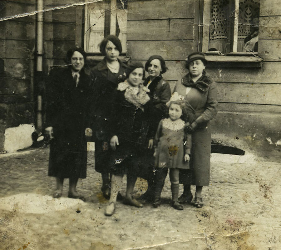 The sisters Liliana and Malka Giske in the foreground of a family photo. Their sister Rachel is standing on the left. On the right at the back is their mother Rosa Giske, Lodz, early 1930s. Rosa and Rachel were both murdered 