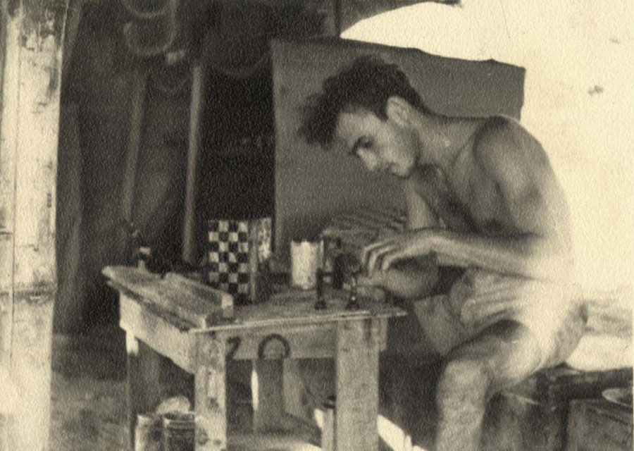 Aryeh Klein carving the chess pieces in front of his tent in the detainment camp in Cyprus