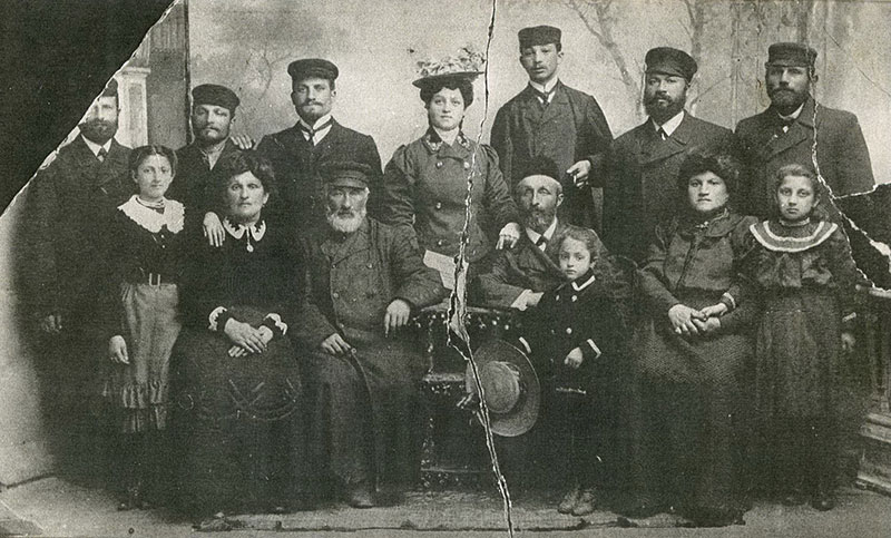 Shoshana (grandmother of baby Rose) standing in the center wearing a hat, next to her husband Mordecai and other family members before the war