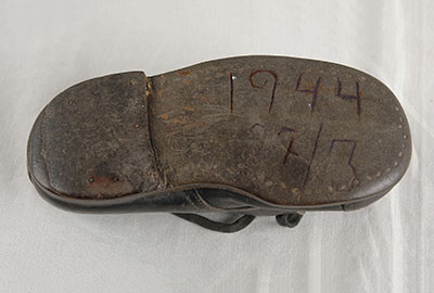 The baby shoe of Hinda Cohen, with the date of her deportation to the death camps carved into the sole by her father