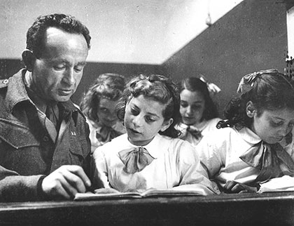 A soldier from Eretz Israel (Mandatory Palestine) serving in the British Army teaches Jewish children Hebrew in a camp in Italy after the war