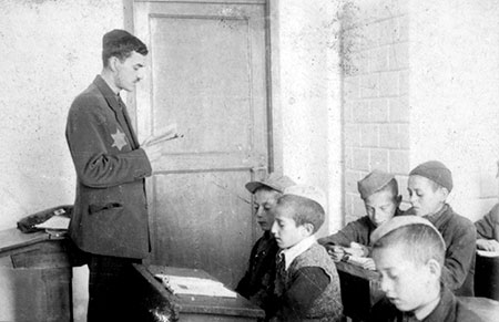 תלמידים ומורה בכיתה בגטו, ככל הנראה בשכונת מרישין בגטו לודז', פולין