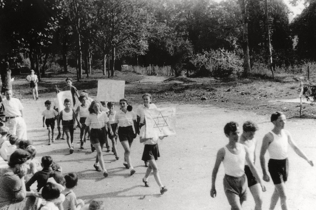 Jewish refugee children march with signs in front of the Chabannes children's home on sports day, France, 26 August 1942