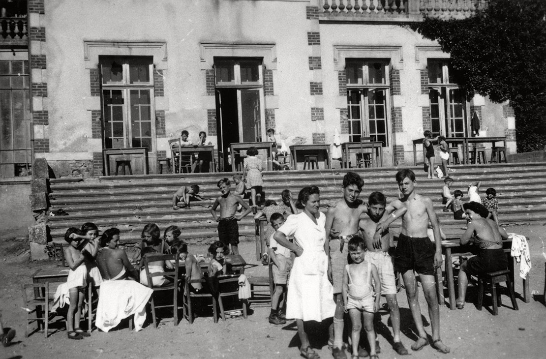 Des enfants juifs réfugiés et des membres du personnel de la maison d'enfants de Chabannes se détendent au soleil devant l'établissement, 26 août 1942