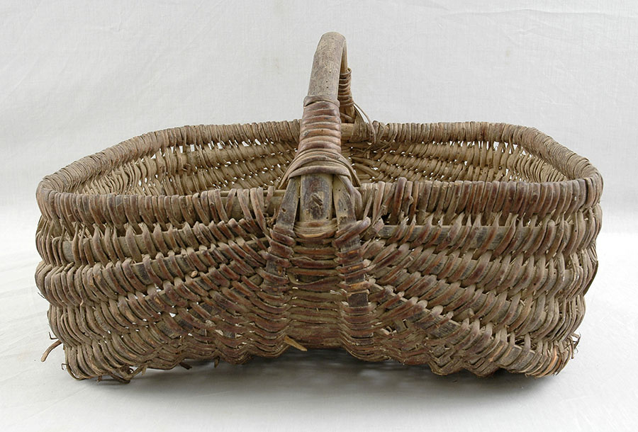 Basket found in the abandoned children's home in Chabannes. The children used wicker baskets to collect chestnuts. Items found at the site include a wicker basket, a trowel, a sickle and a wheel