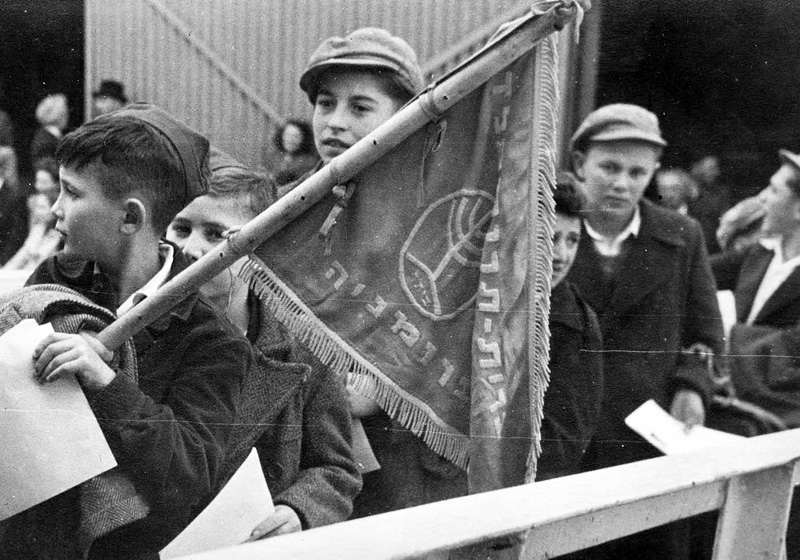 Members of the Beitar youth movement from the "Ilania" children's village in Apeldoorn, the Netherlands, boarding the "Negba" with the Beitar Romania flag