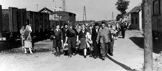 Polish Holocaust survivors disembarking from a train along the route of the Bricha