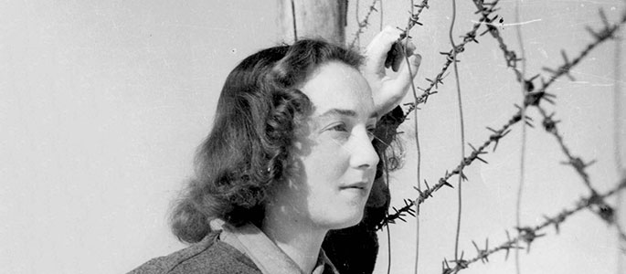Yalina Lebovicova standing by the barbed wire in the Nováky forced labor camp, Slovakia. Yalina was an actress in the camp’s theater