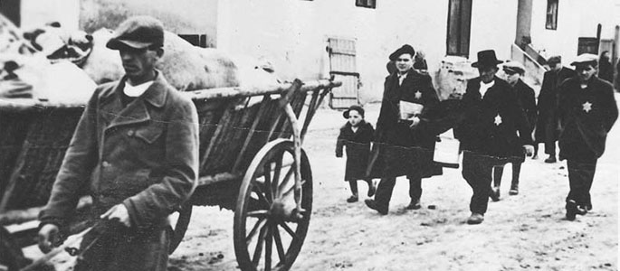 יהודים הולכים ליד עגלה עמוסה בחפצים בעת גירושם מסלובקיה, 1942