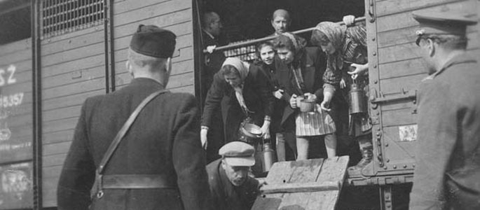 אנשי המיליציה הסלובקית סוגרים את דלתותיה של רכבת בה מגורשים יהודים מסלובקיה, 1942