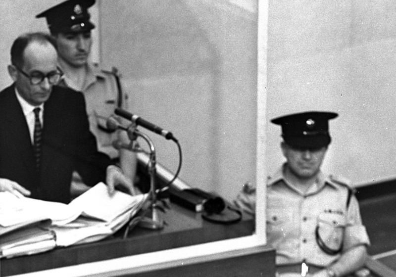 אדולף אייכמן בעת משפטו. למטה: סניגורו, רוברט סרווציוס