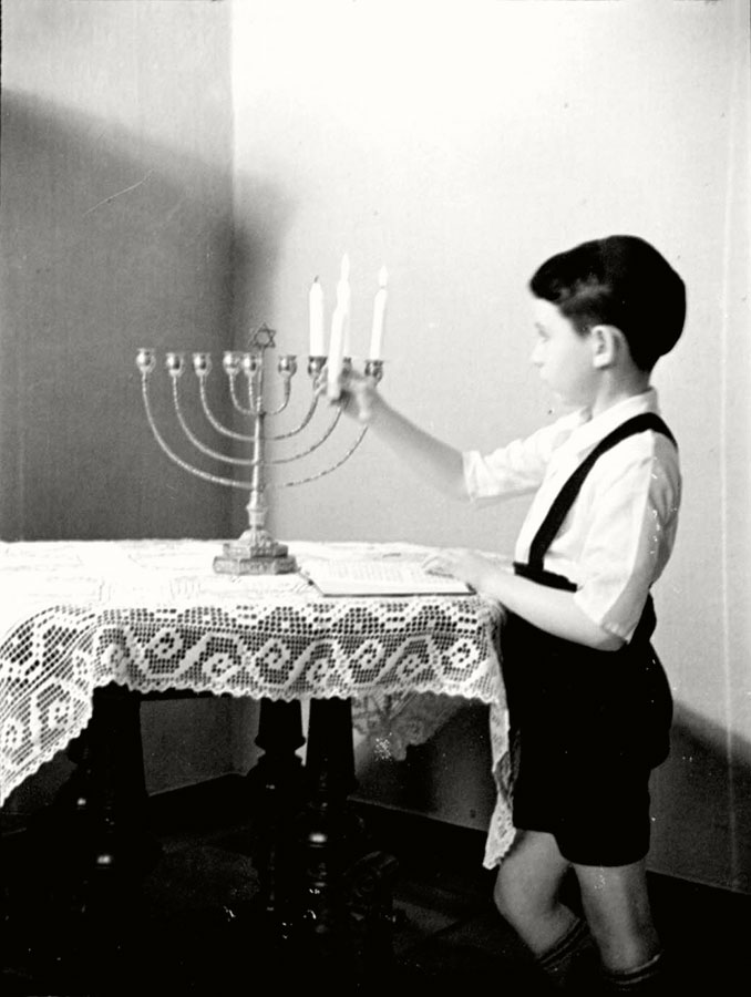 Berlin, Germany, 1930s, a boy lighting a Hanukkah candelabrum on Hanukkah