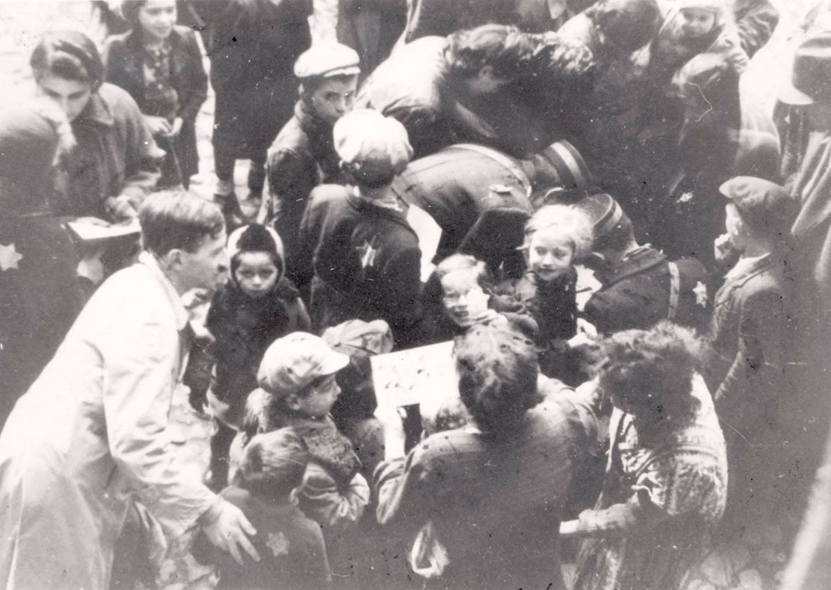 Lodz, Poland, 1941, Nachman Zonabend distributing sweets to children at Hanukkah