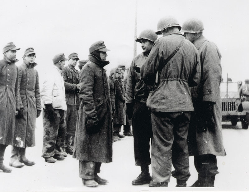 החייל האמריקאי רוברט ברנד (שלישי מימין) חוקר שבויים גרמנים 