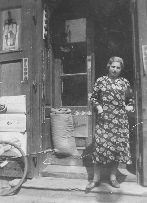 ברכה איגז' לבית צינר בפתח החנות ששימשה לפרנסת המשפחה, בקשצ'בה, הונגריה, 1939
