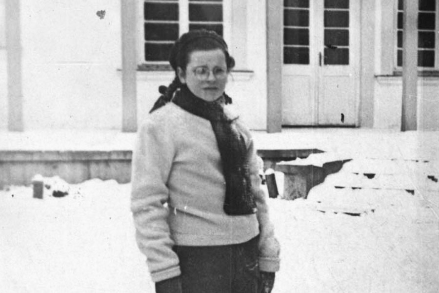 Chana Grynberg standing in the snow holding her school bag in Otwock