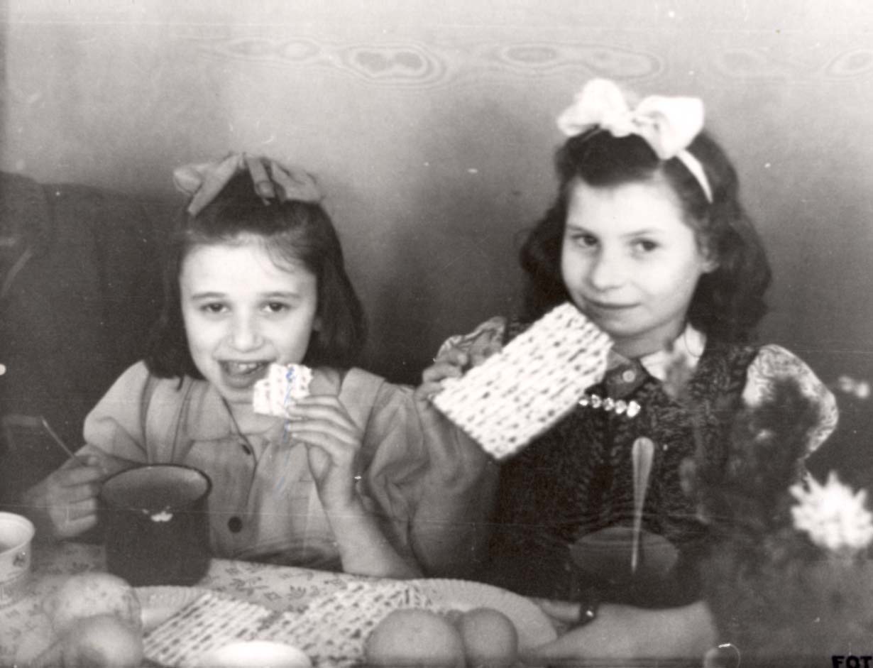 Girls eating matzah on Passover at the Rothschild Center, Vienna, Austria, postwar