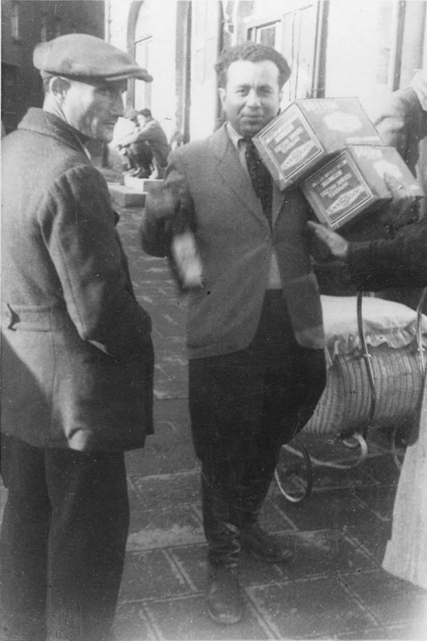 A man taking boxes of matzah for Passover at the Eggenfelden DP camp, Germany, postwar