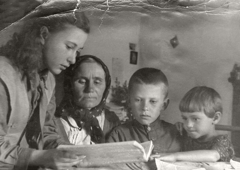 ldina leyendo un libro a Ludwiga (Nina), Gennady y Galya, septiembre de 1946