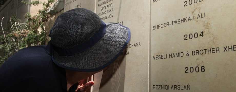 Vera Ugljesic, die von Zlatan Ugljesic gerettet wurde und ihn nach dem Krieg heiratete, küsst seinen Namen auf der Mauer im Garten der Gerechten, Mai 2013