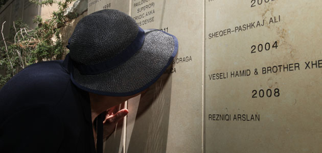 Vera Ugljesic, who was saved by Zlatan Ugljesic and married him after the war, kisses his name on the wall in the Garden, May 2013