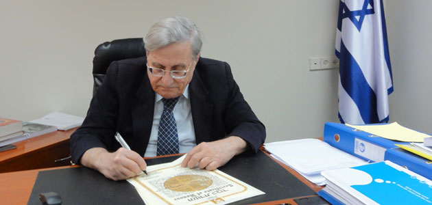Der Vorsitzende der Kommission Richter Yaacov Turkel unterschreibt die Ehrenurkunden