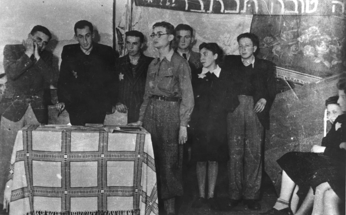 אהרון יעקבסון (שני משמאל, בחולצה שחורה), פעיל ציוני וממנהיגי הנוער בגטו לודז', וחבריו ל"חזית דור בני-מדבר" חוגגים את ראש השנה בגטו. לודז', ספטמבר 1942