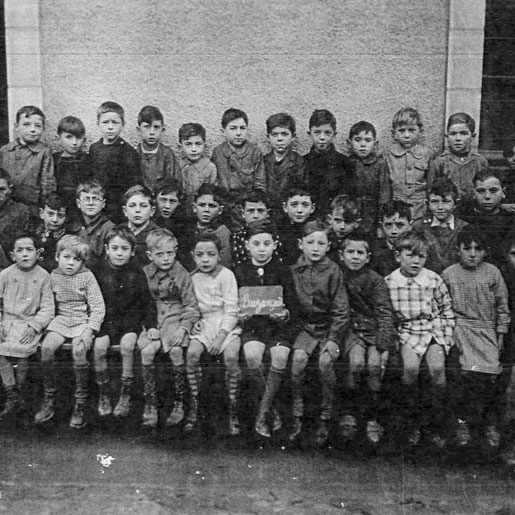 Ehud Loeb (center, holding a sign) at a school in France during the war